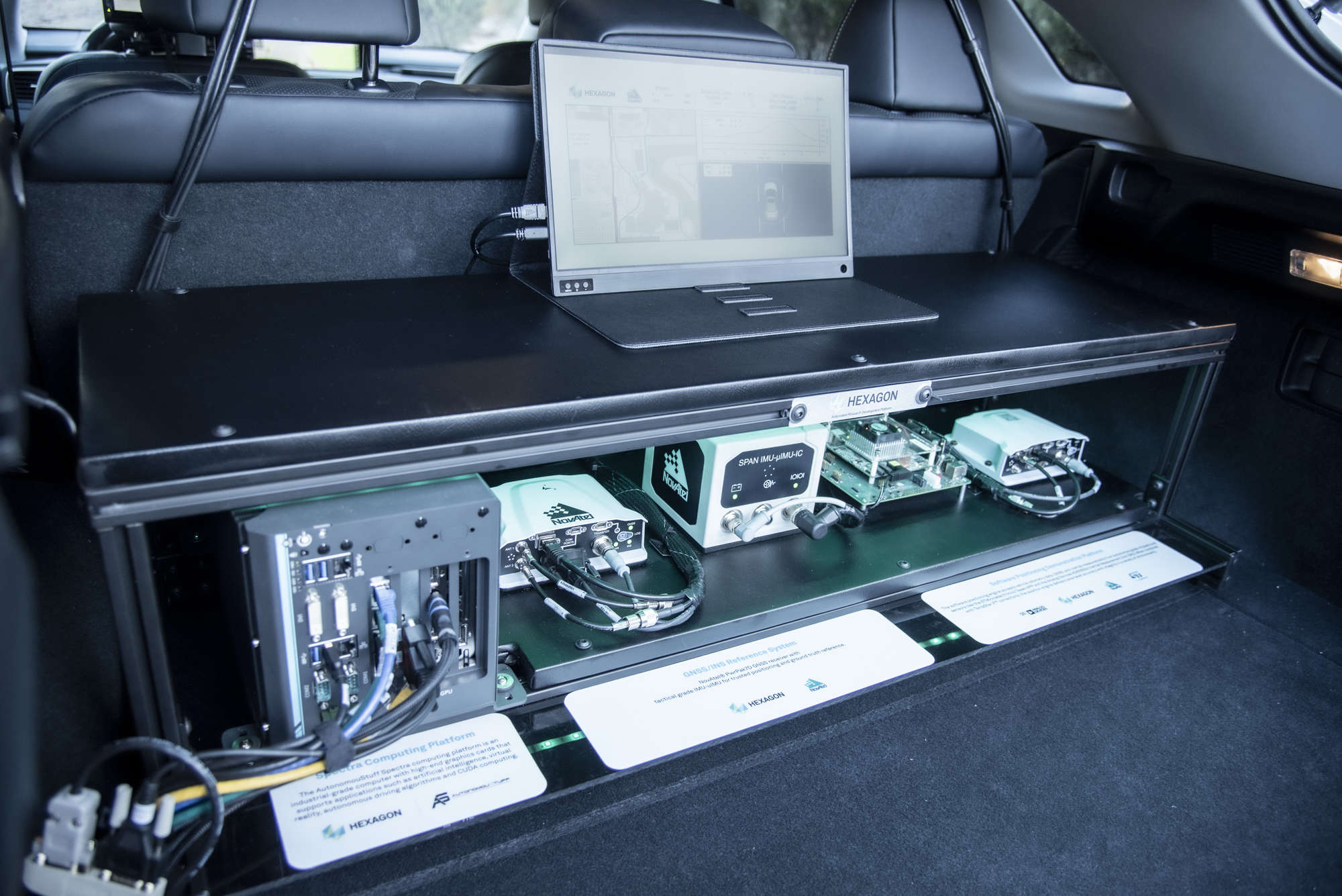 Photograph of GNSS antennas, receivers, and inertial measurement units inside the trunk of a vehicle